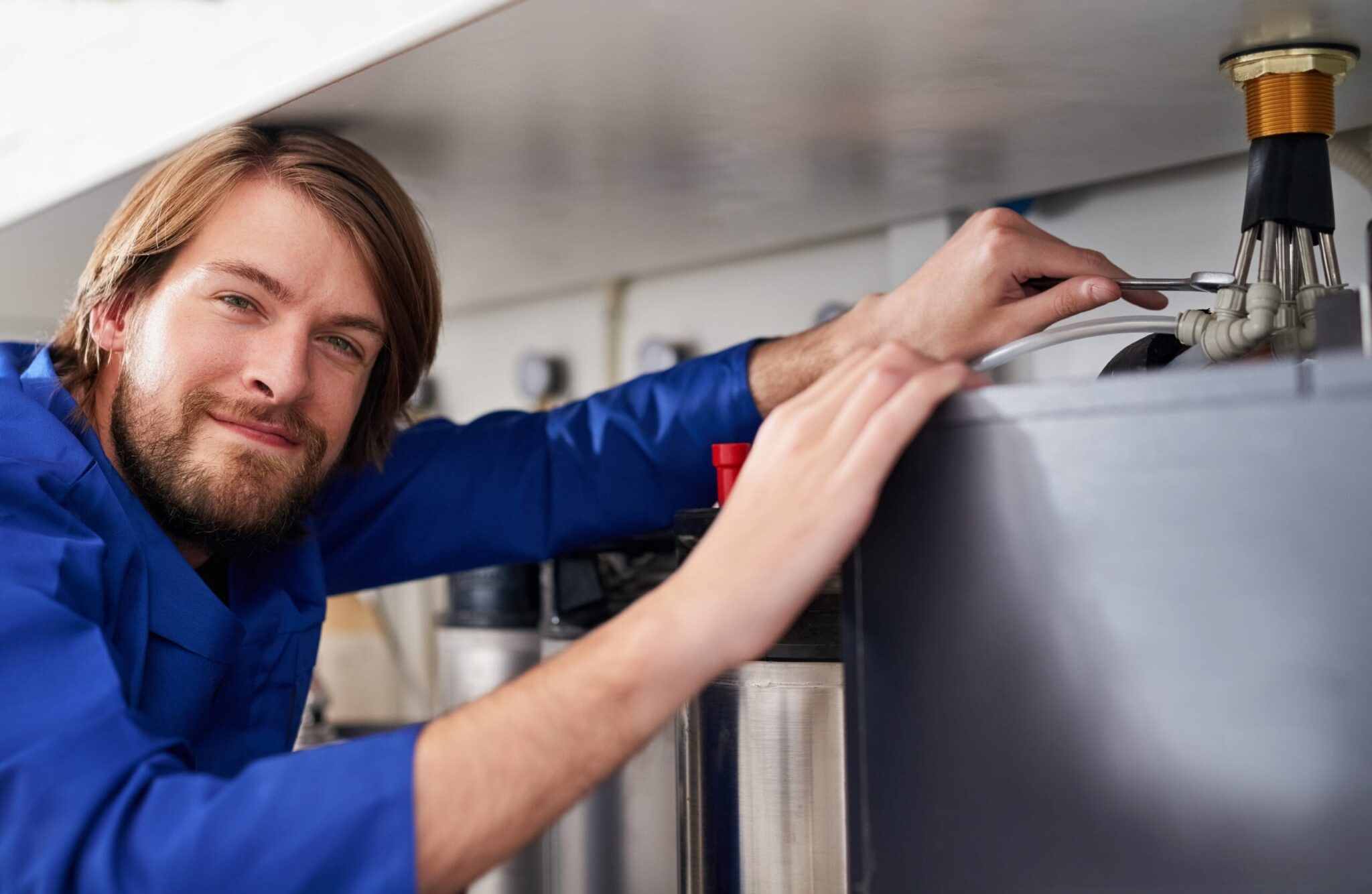 Technician servicing a residential water heater tank in Morgan Hill