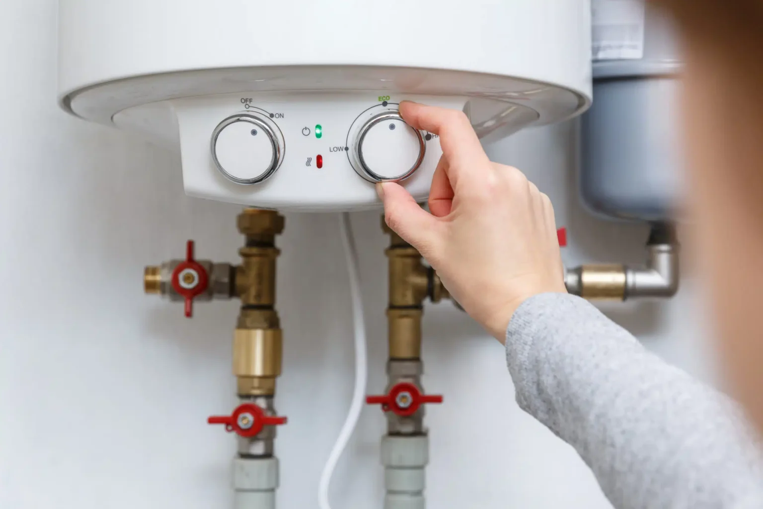 Homeowner adjusting the temperature controls on a water heater in Morgan Hill
